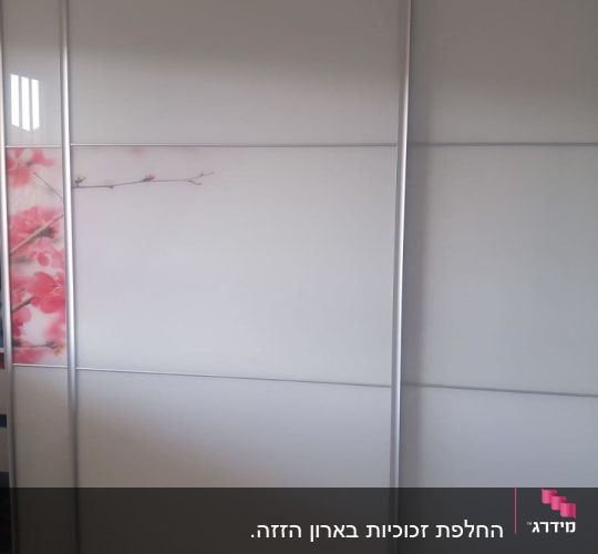 ארון הזזה עם דלתות לבנות ודוגמת פרחים